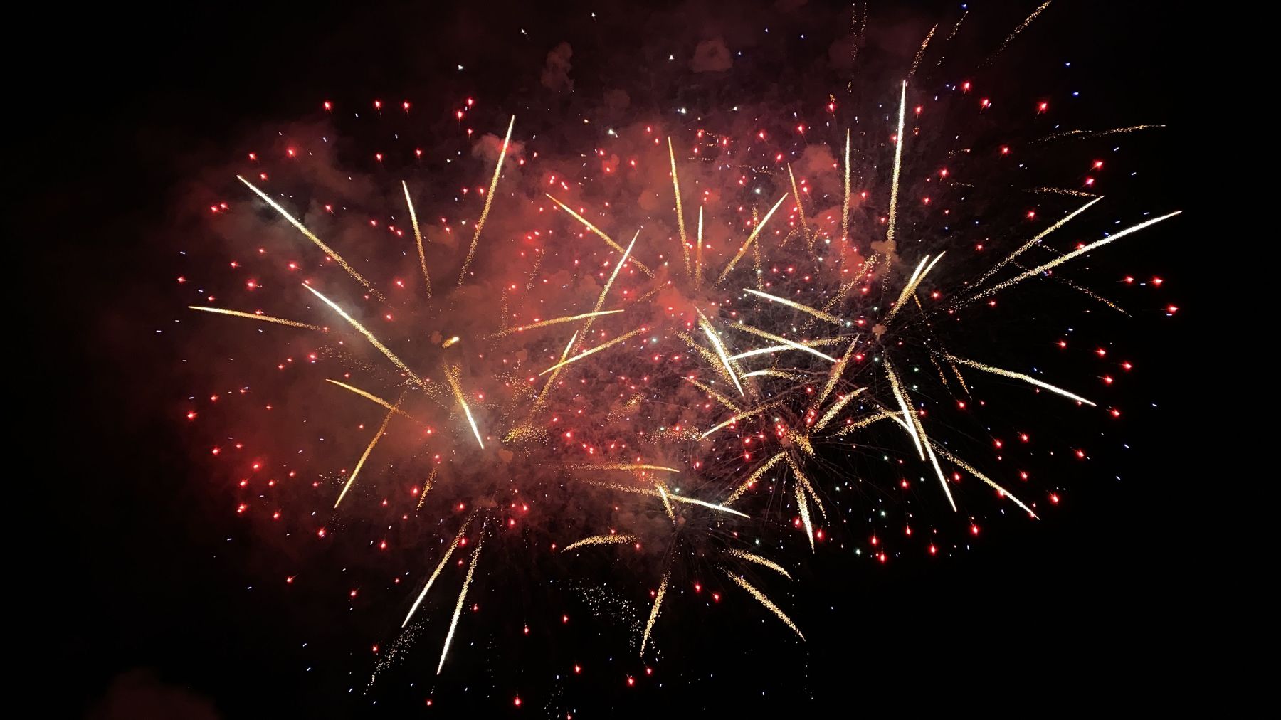 A wide fireworks grand finale lighting the night sky