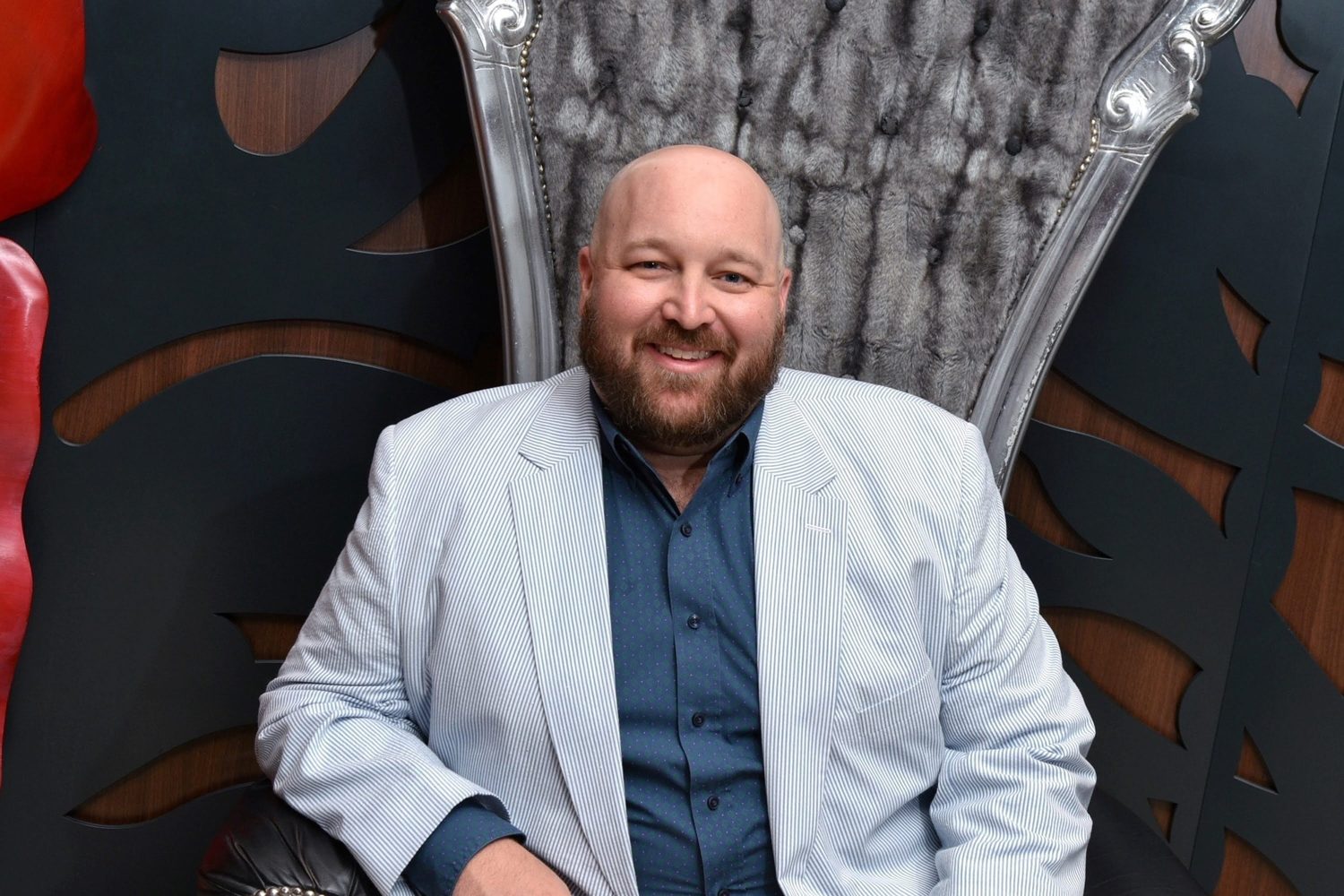 Stephen M. Yoss, Jr. seated on an ornate throne chair